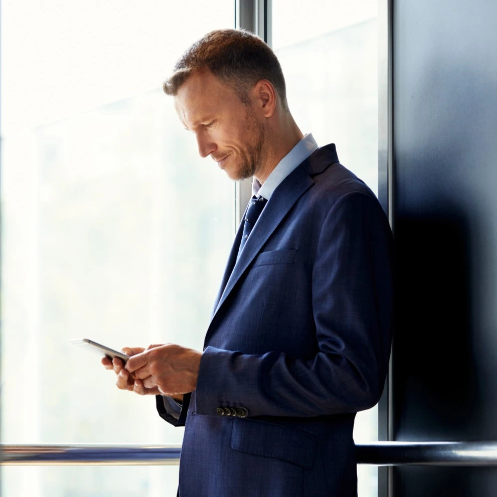 A man standing, holding a phone