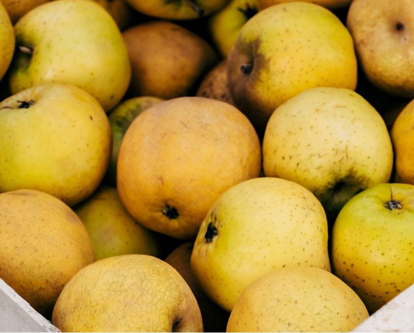 Yellow apples in a wooden box