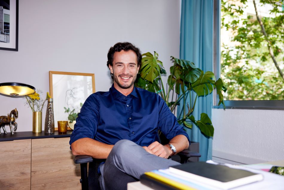 Man with blue shirt sitting on a chair